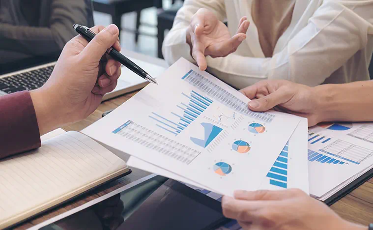 Integrated Capabilities Two business people looking over a financial report.